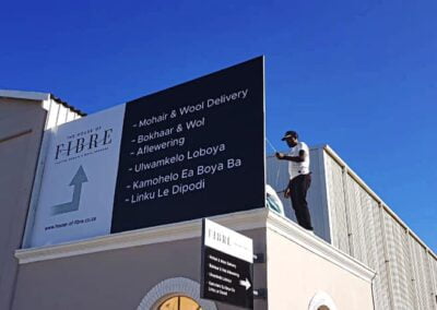 two men on top of a building installing branding